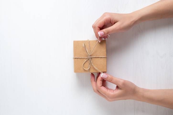 小さな茶色のクラフトボックスに麻ひもを結んでいる様子