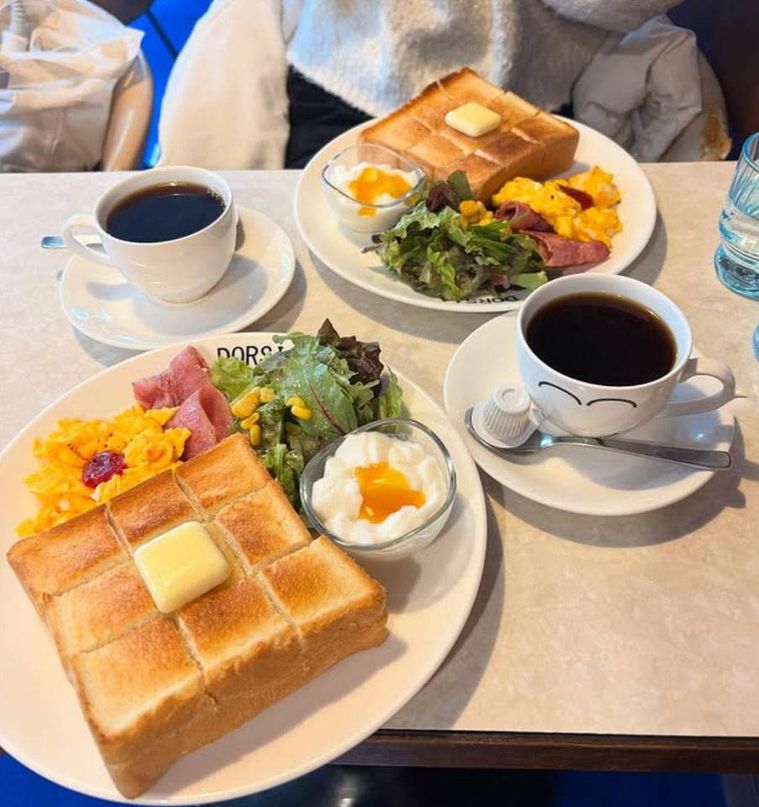 ロゴ入りの白いお皿に盛られたモーニングとコーヒー