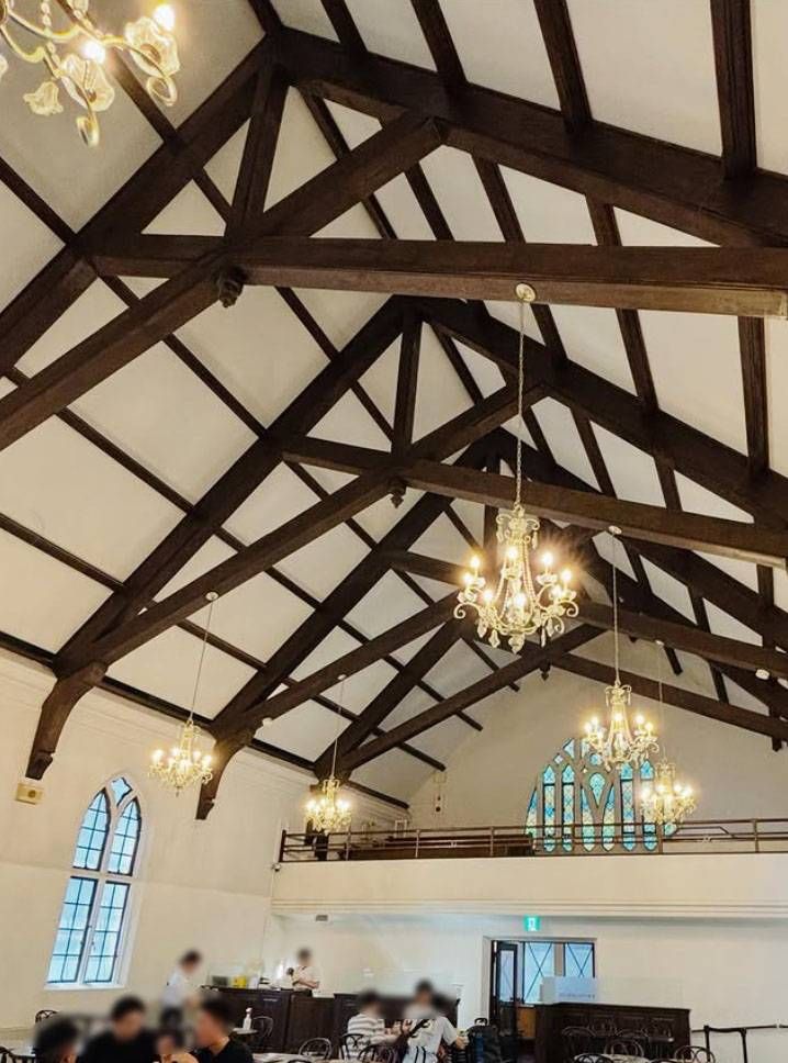 アーチ型の窓、天井からシャンデリアがかけられたカフェ フロインドリーブ 本店の店内