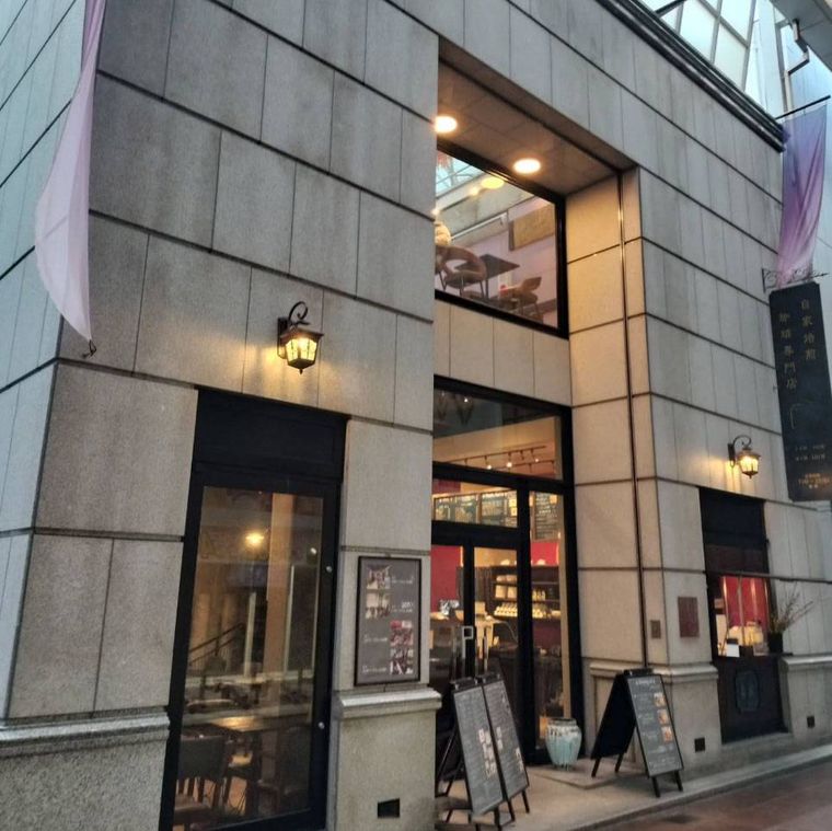 コンクリートの外壁に照明がついた珈琲春秋コウベ 三宮店の外観