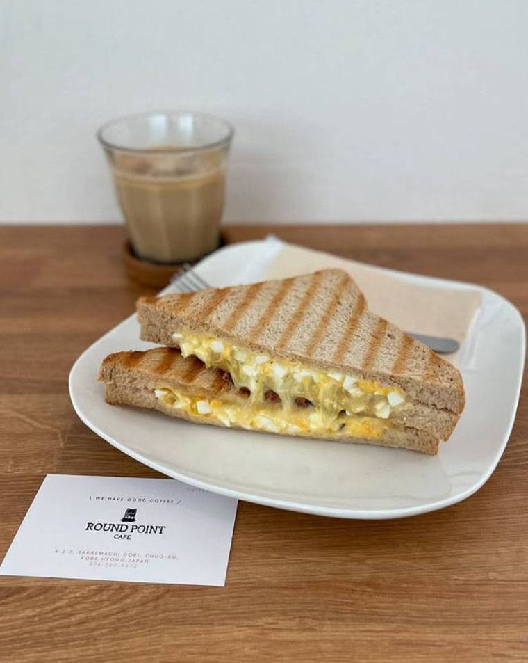 白いお皿に盛られた エッグチーズサンドとカフェラテ