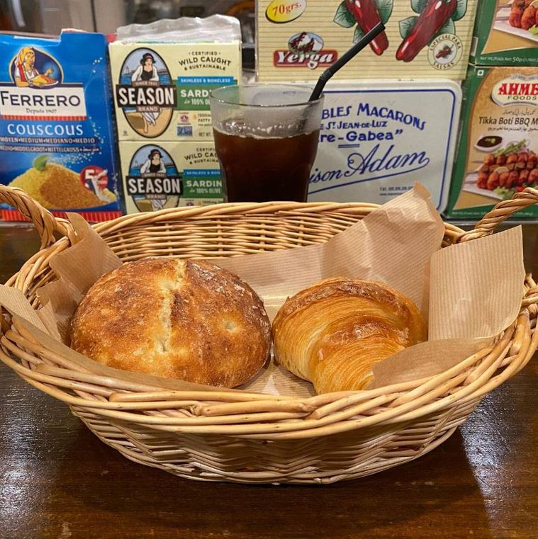 かごに入ったクロワッサン モンスティルとパン・ド・ポム・ド・テール、アイスコーヒー