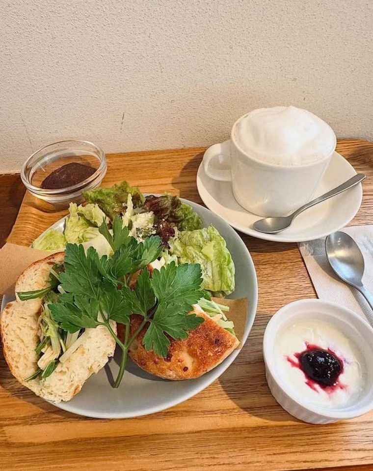 木のトレイにのせられたフォカッチャサンドとカフェオレ