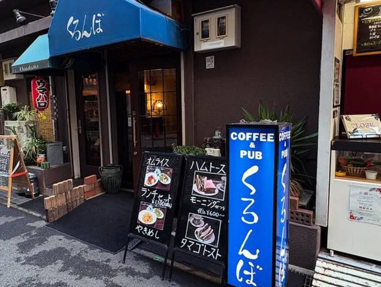 ブルーの日よけ、看板が設置されたくろんぼの外観