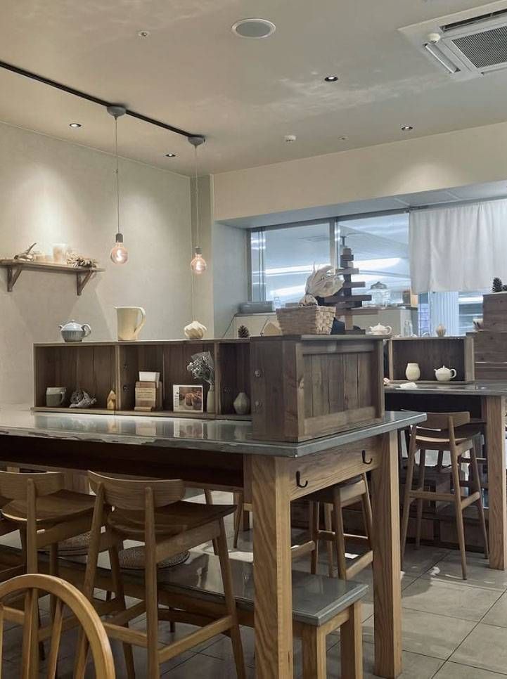 ベージュを基調とした内装に木のテーブルセットが置かれたリンク ツリーの店内