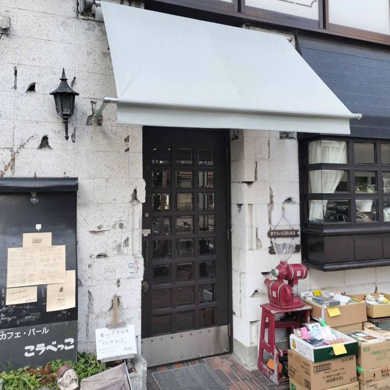 白い日よけがかかったカフェ・バール こうべっこの外観