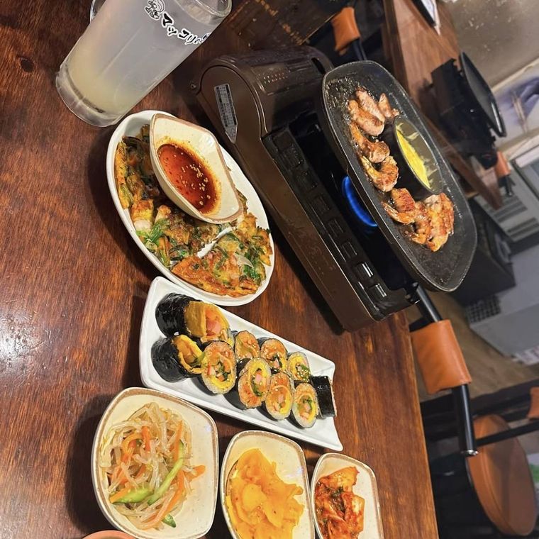 器に盛られたキンパとチヂミと野菜、鉄板で焼かれたサムギョプサル