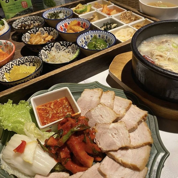 器や小鉢に盛られたキムチ、豚肉、野菜