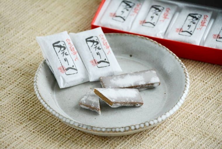 お皿にのせられた音羽屋のカットされた代表銘菓飛騨のかたりべと個包装パッケージが並んでいる様子