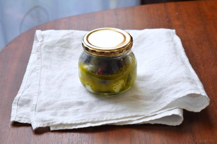 テーブルに置いたチーズのオリーブオイル漬けの瓶