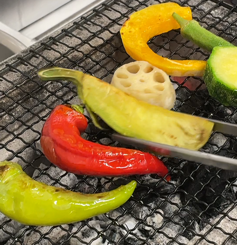 薪火で旬野菜をローストしている