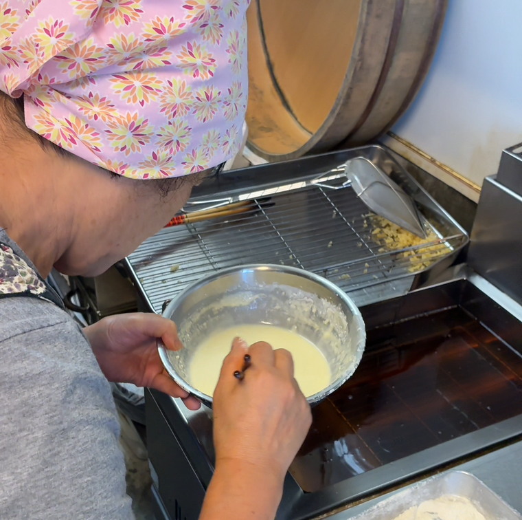 天ぷらを揚げる女将さん