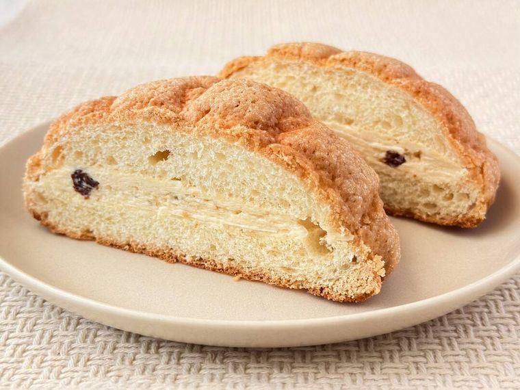 皿に盛り付けられたファミリーマートのラムレーズンフェアのラムレーズンバターメロンパンの断面