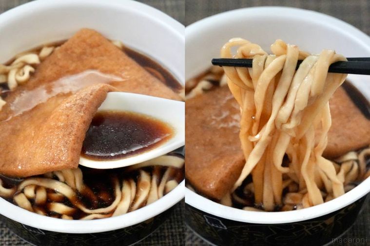 黒いどん兵衛カップうどんのスープをすくう白いれんげと黒い箸