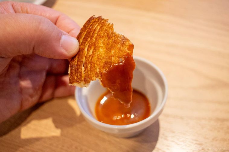 ちぎったデニーズクリスピークレープをキャラメルソースにつけている様子