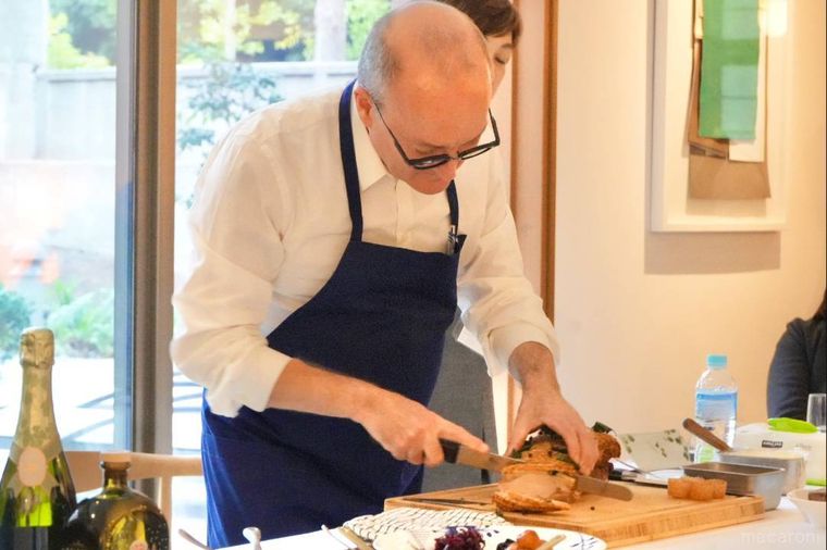 シェフがクリスマスのメイン料理のローストポークをカットする様子