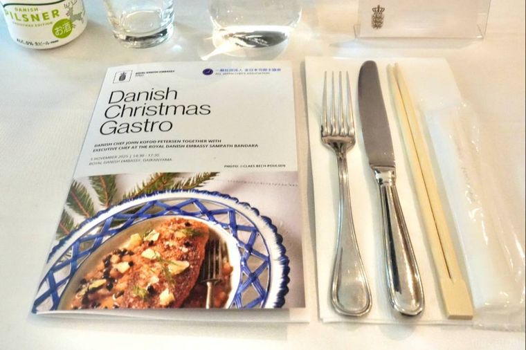 テーブルにのったガストロノミーイベントのリーフレットとカトラリーとグラス