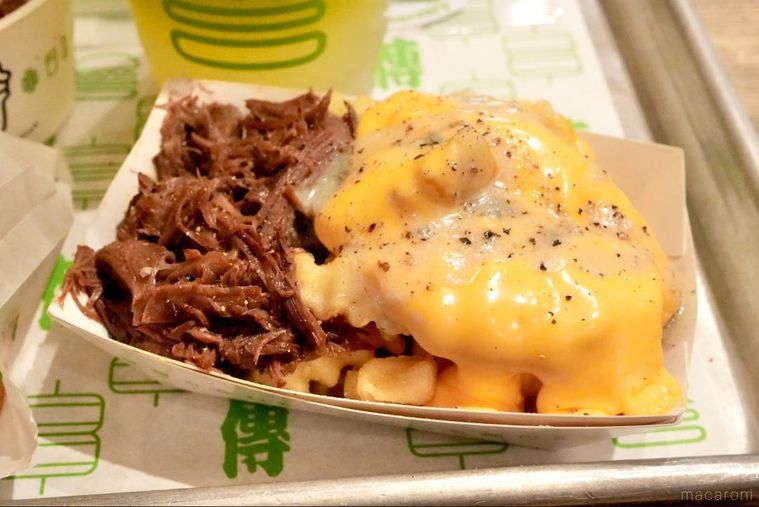 紙トレーにのった牛頬肉の煮込みとチーズがトッピングされたフライドポテトメニュー