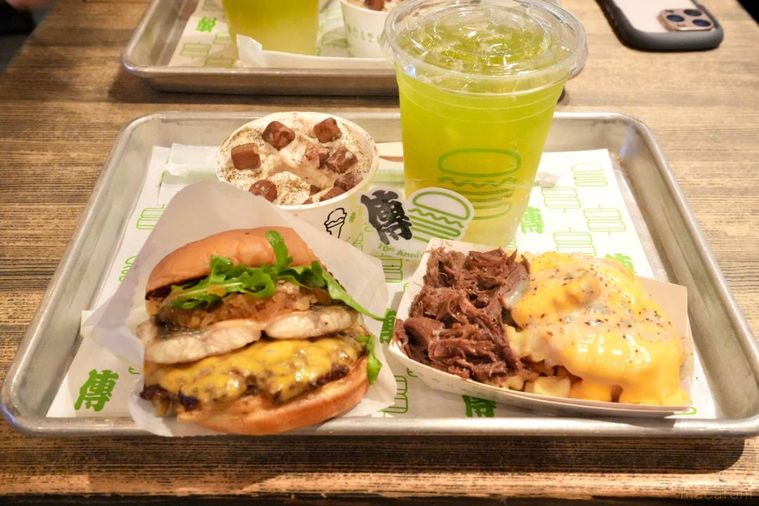 アルミのトレーにのったハンバーガーとポテトとドリンクとスイーツ