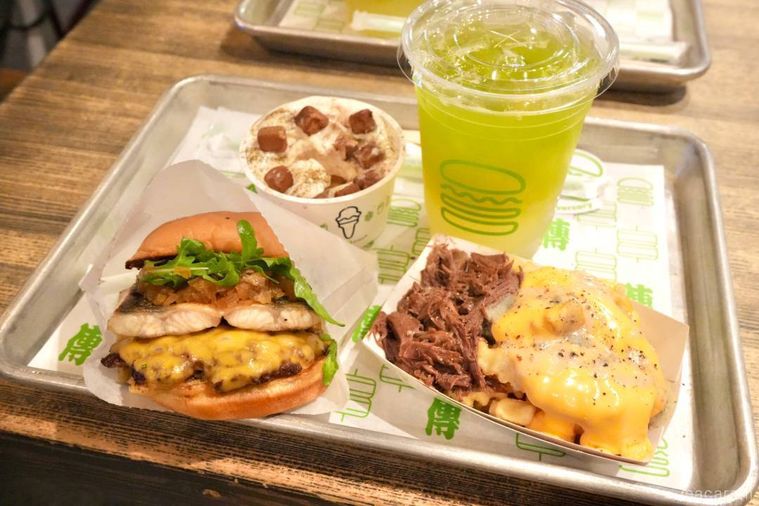 アルミのトレーにのったハンバーガーとポテトとドリンクとスイーツ