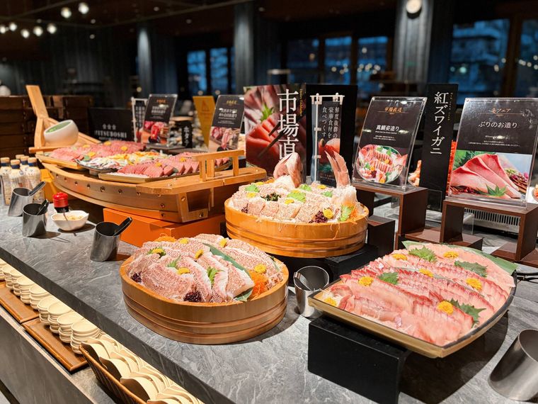 バイキングに並んだぶりのお造りや真鯛の姿造りなどの海鮮類