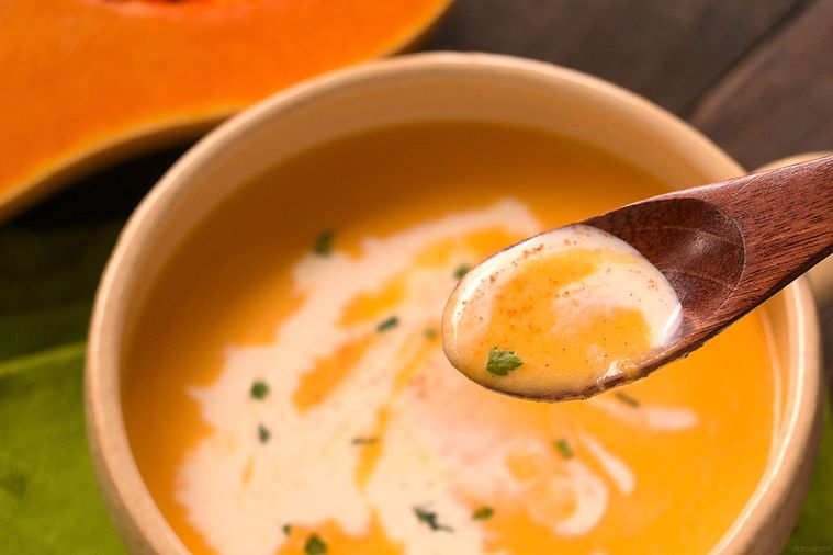 バターナッツかぼちゃのポタージュを木のスプーンですくう様子