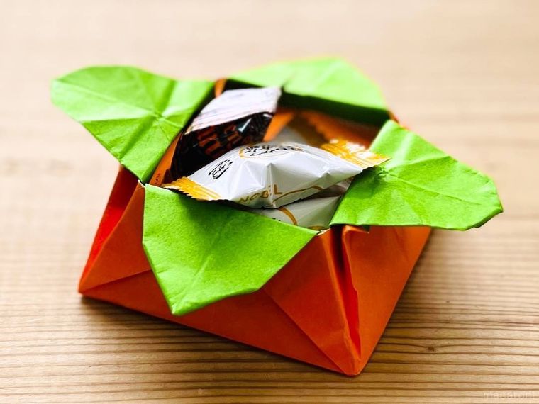 折り紙で作った柿の小物入れにキャンディーを入れた様子