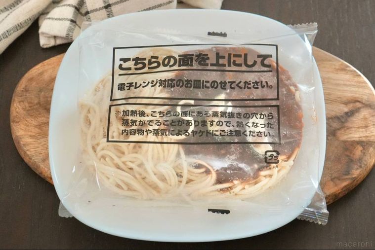 木のカッティングボードと白い皿にのった冷凍ボロネーゼ