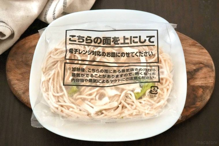 木のカッティングボードと白い皿にのったシュクメルリ風冷凍パスタ