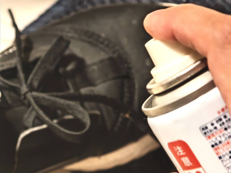 靴に防水スプレーをふきかける様子