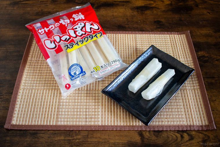 サトウ食品サトウの切り餅いっぽんのパッケージと黒い和皿に置かれた2本のお餅