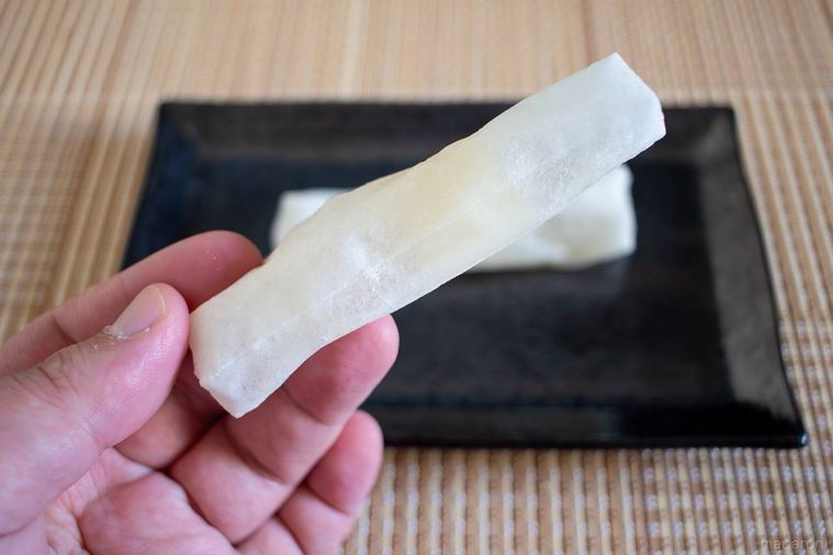 焼いたサトウ食品サトウの切り餅いっぽんを1本手で持っている