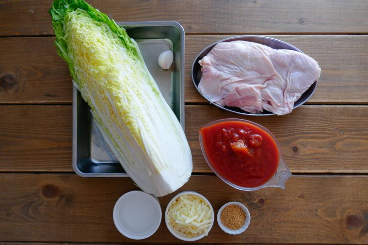 白菜と鶏もも肉のトマト鍋の材料が並ぶ木製テーブル