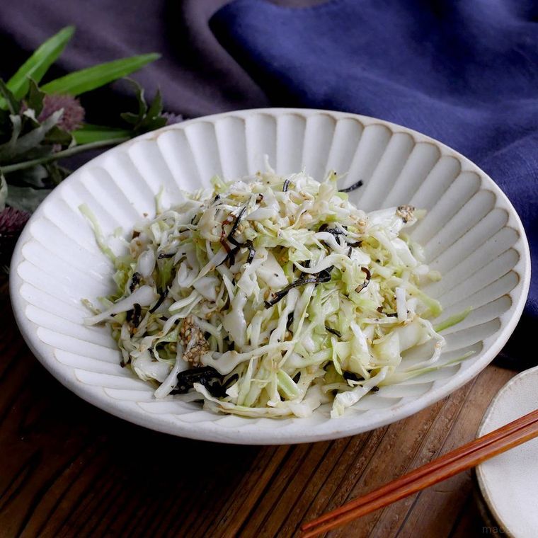 白い皿に盛り付けた千切りキャベツと塩こんぶのごま油和え