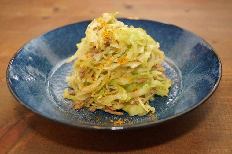 青い皿に盛り付けた千切りキャベツのカレー炒め