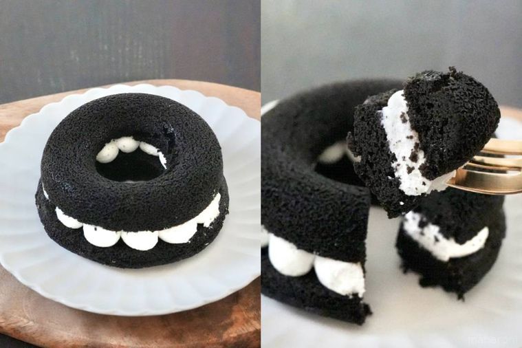 木のカッティングボードと白い皿にのった黒い焼きドーナツサンドと金のフォークで食べる様子