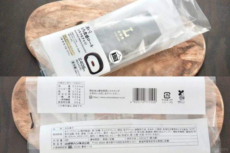 木のカッティングボードにのった黒いもち食感ロールとパッケージの原材料表示