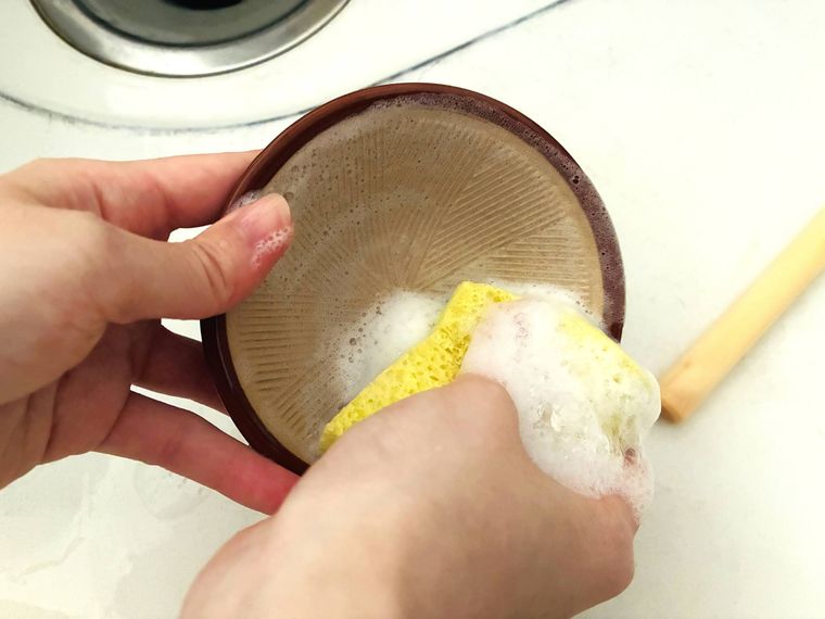 ミニすり鉢を洗剤を付けたスポンジで洗っている
