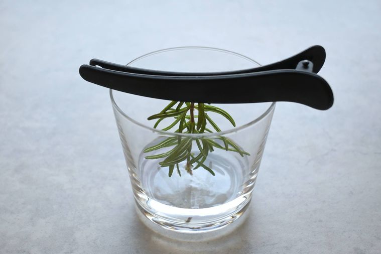 クリップで挟んだローズマリーがグラスの中に固定されている