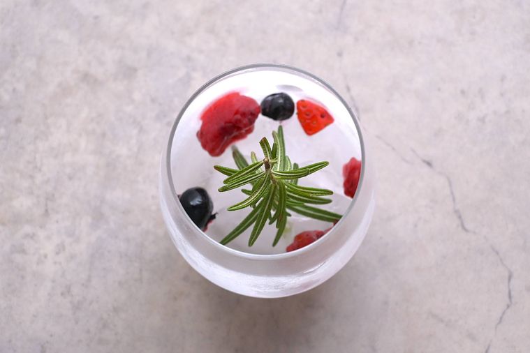 ローズマリーを凍らせたグラスに冷凍フルーツを入れた様子