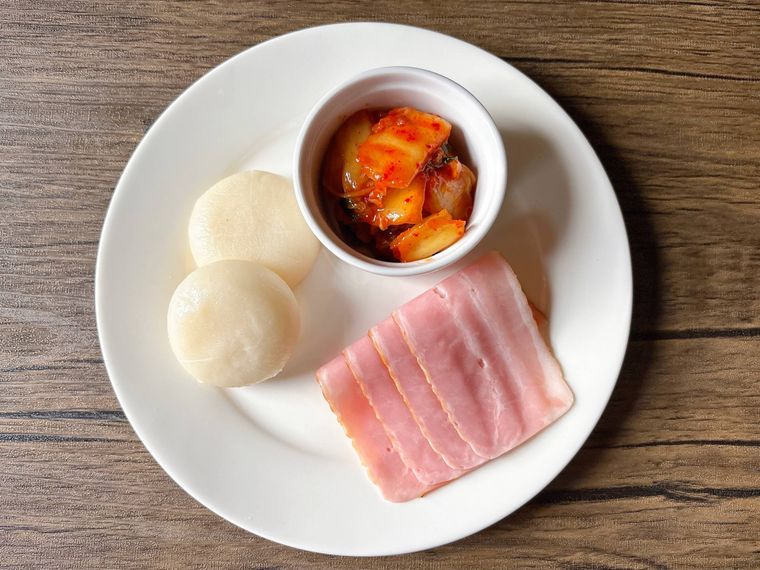 丸皿におかれたキムチ、ベーコン、もち
