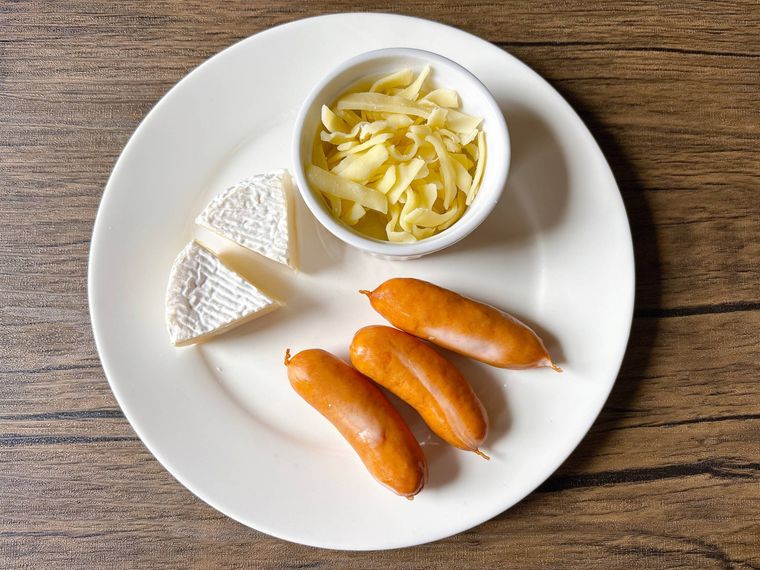 丸皿におかれたとろけるチーズ、ウインナーソーセージ、カマンベールチーズ