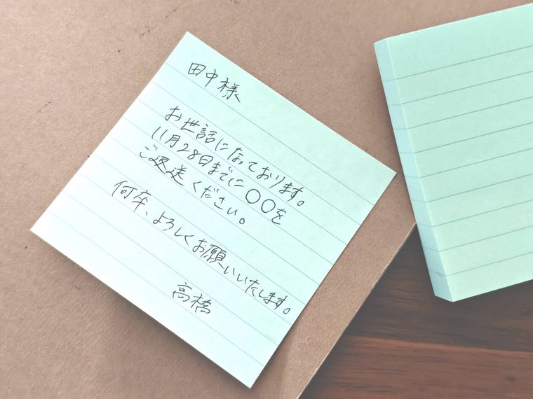 グリーンふせんに文字を書いている様子