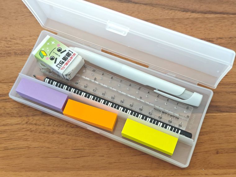 スマホが立つペンケースのなかに文房具を入れている様子