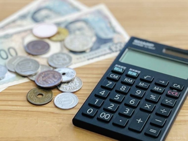 テーブルの上にお金と電卓が置かれている様子