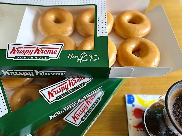 テーブルに置かれたクリスピー・クリーム・ドーナツの箱入りドーナツ