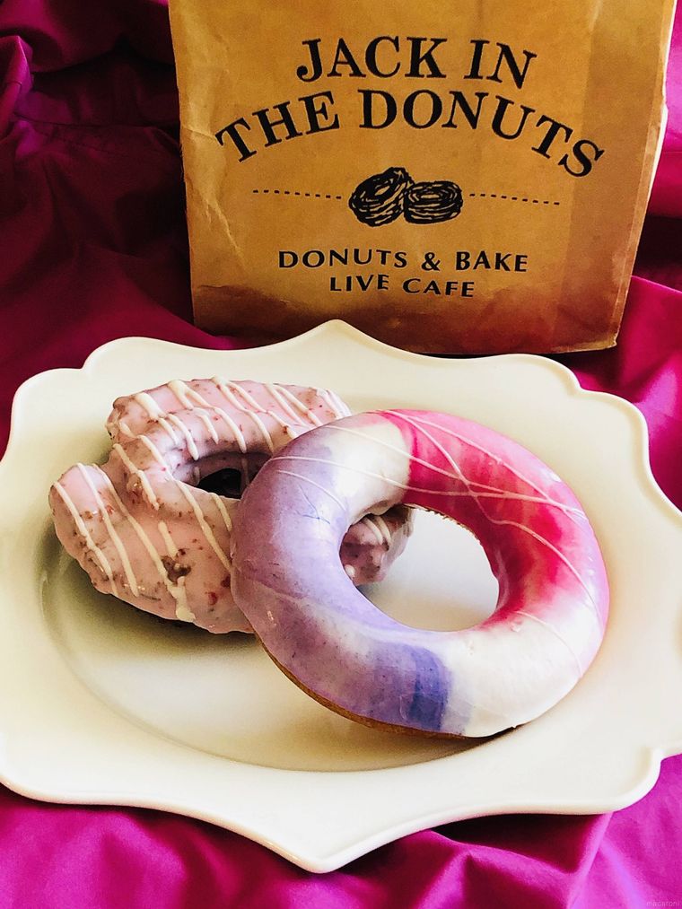 白い皿に置かれたジャック イン ザ ドーナツのカラフルなドーナツ