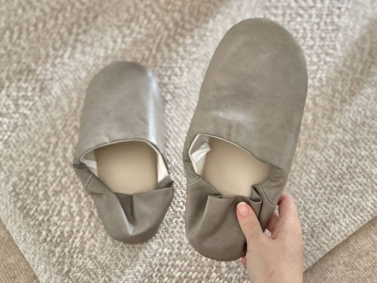 片方を持ち上げたフェイクレザースリッパ
