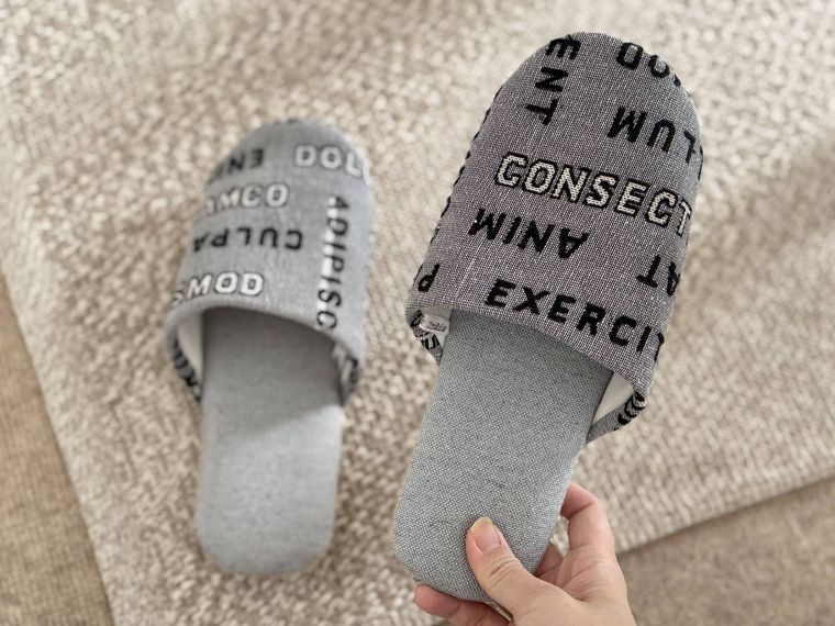 片方を持ち上げたロゴジャガードスリッパ