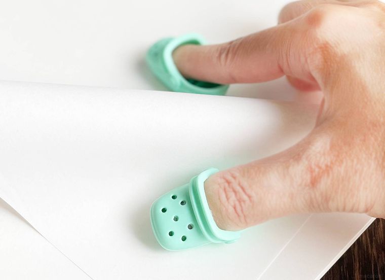 指サックで紙をめくっている